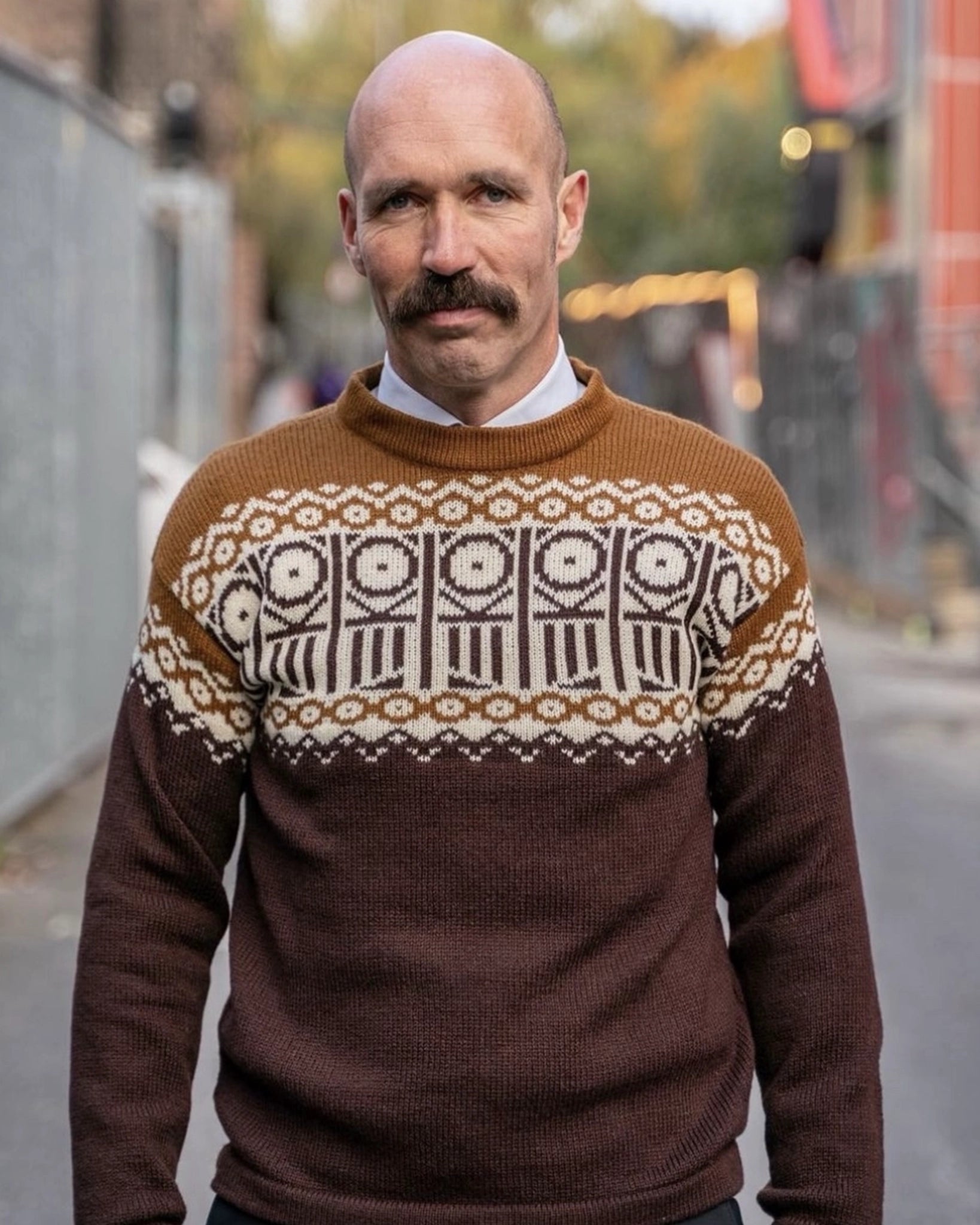 Mann iført den offisielle Kaizers Orchestra-genseren fra Vikingstrikk, inspirert av mariusgenserens tradisjonelle uttrykk, med mønster i brun og naturhvit.