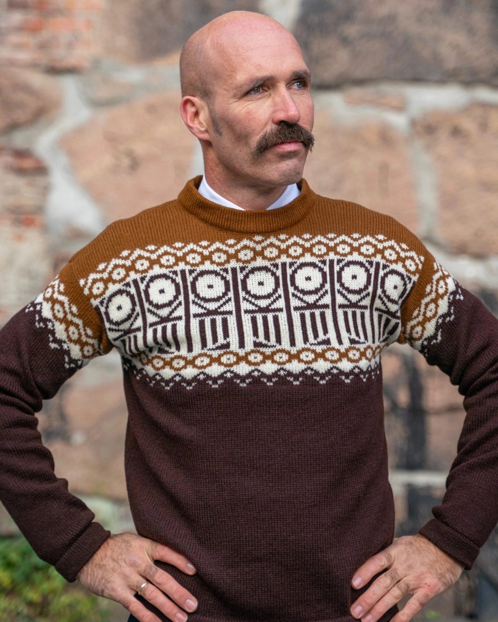 Mann iført ferdigstrikket Kaizers Orchestra-genser fra Vikingstrikk, med logo integrert i mønsteret og snitt inspirert av mariusgenseren.