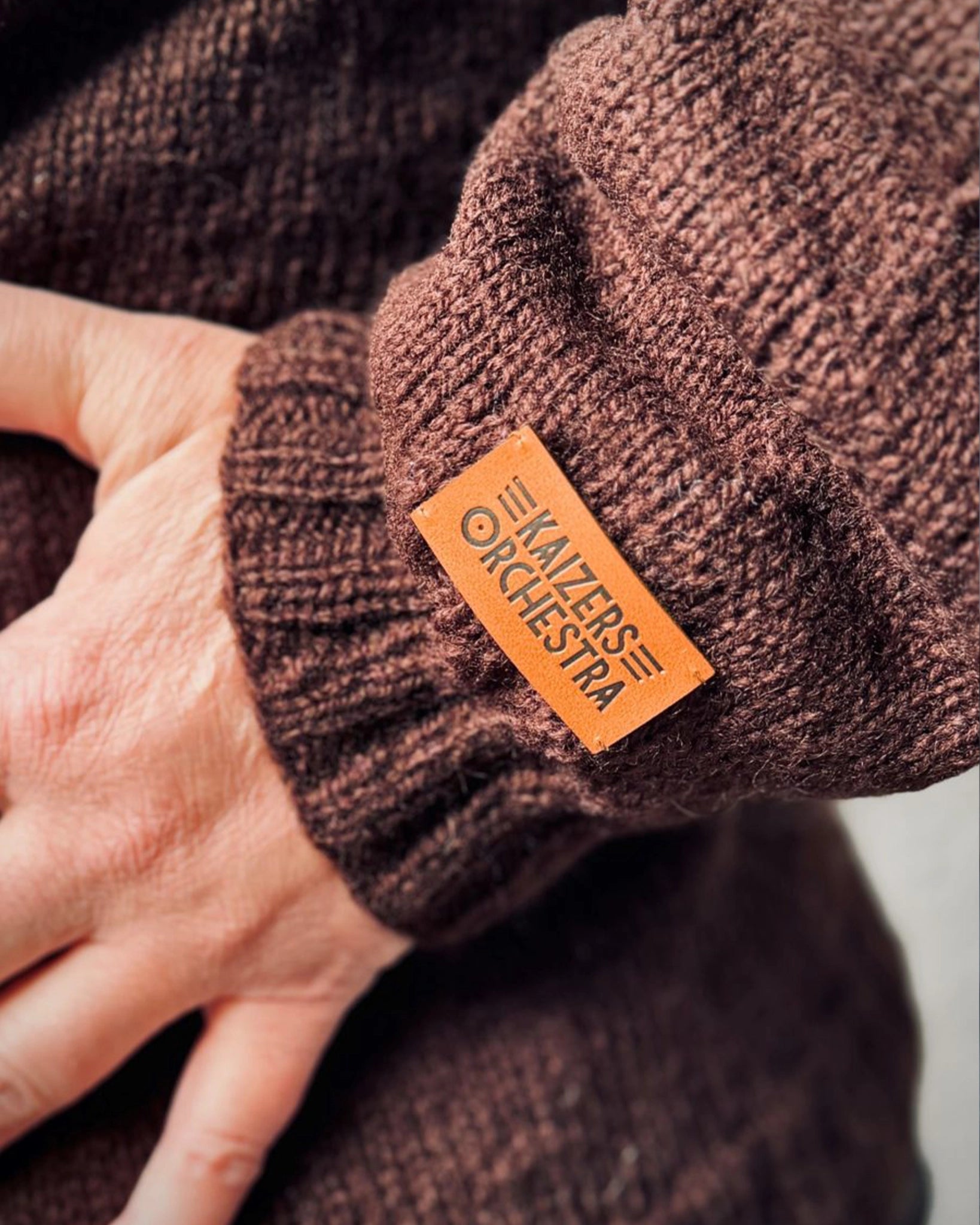 Detaljbilde av Kaizers Orchestra-genser fra Vikingstrikk, offisielt produkt inspirert av mariusgenserens tradisjon, med skinnlapp som viser autentisitet.