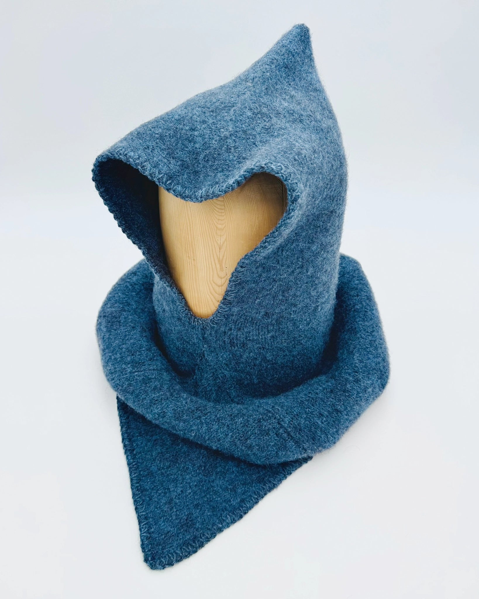 Produktfoto av blå Vikinghette fra Vikingstrikk, laget i myk ull med spiss hette og bred skulderkrage.
