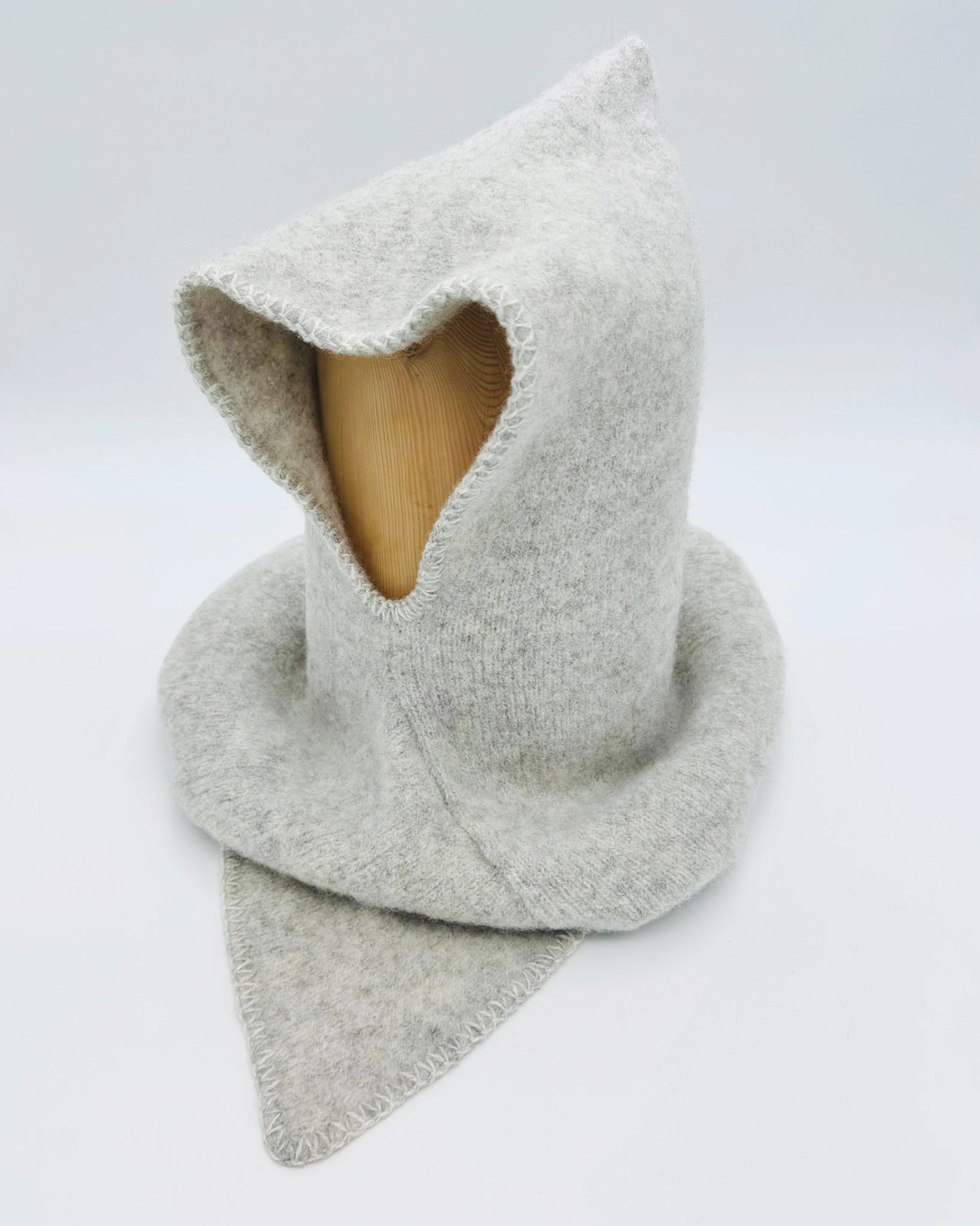 Produktfoto av lys grå Vikinghette fra Vikingstrikk, laget i myk ull med spiss hette og bred skulderkrage.