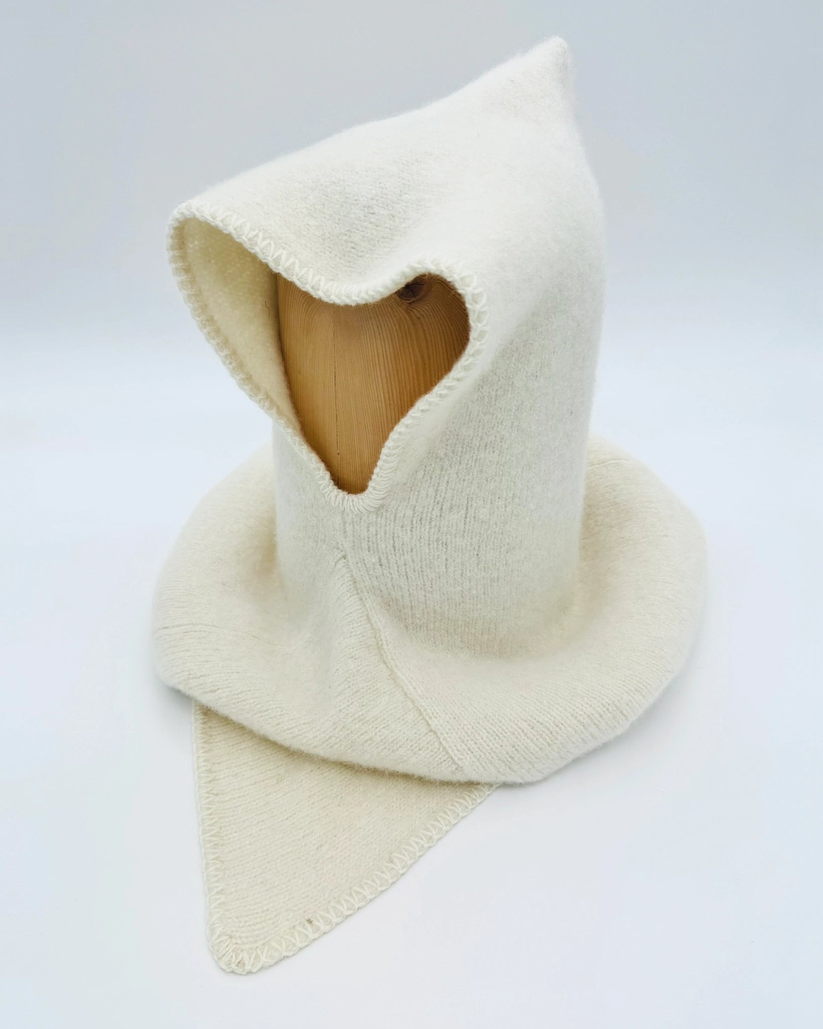 Produktfoto av hvit Vikinghette fra Vikingstrikk, laget i myk ull med spiss hette og bred skulderkrage.