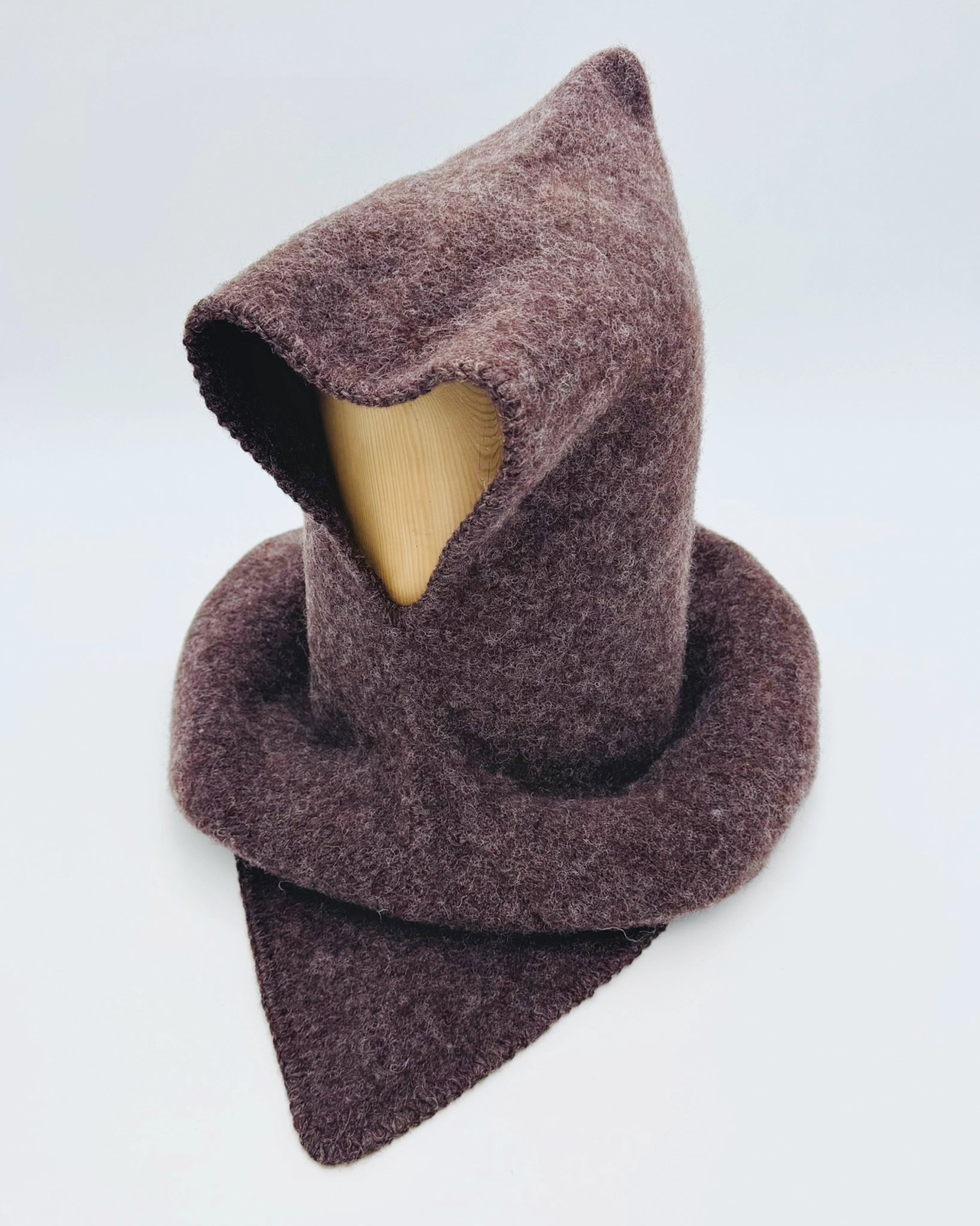 Produktfoto av mørk brun Vikinghette fra Vikingstrikk, laget i myk ull med spiss hette og bred skulderkrage.