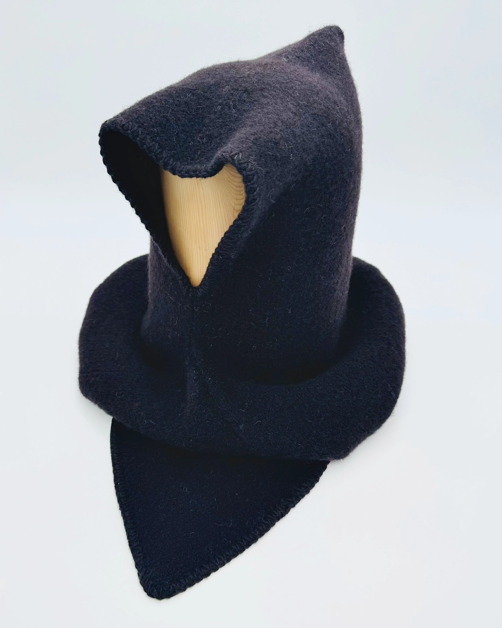 Produktfoto av svart Vikinghette fra Vikingstrikk, laget i myk ull med spiss hette og bred skulderkrage.