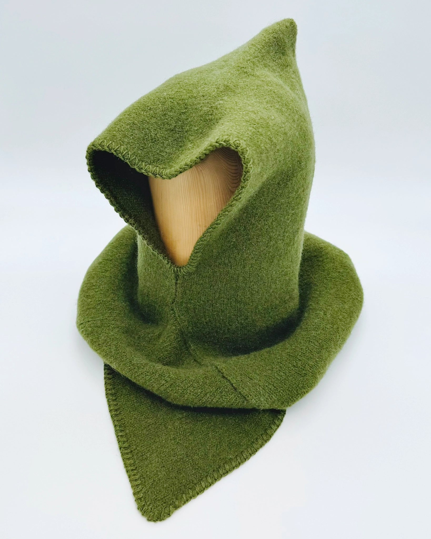 Produktfoto av grønn Vikinghette fra Vikingstrikk, laget i myk ull med spiss hette og bred skulderkrage.